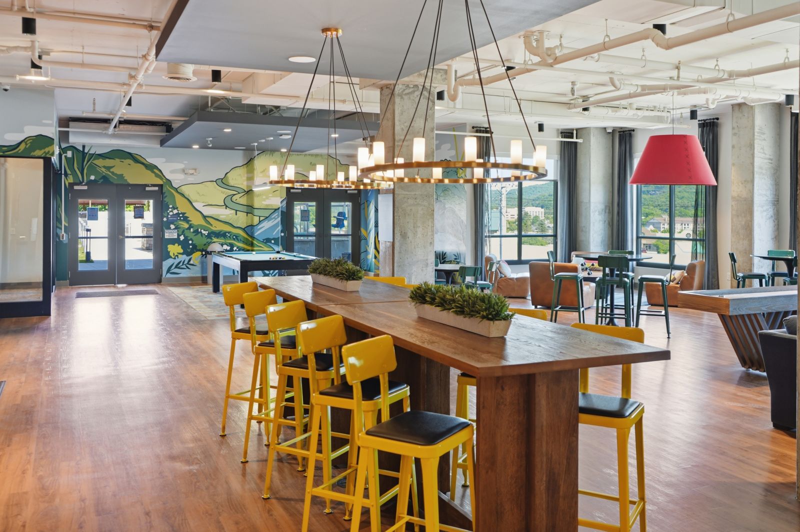 Spacious resident clubhouse featuring collaborative seating, entertainment areas, and mountain-inspired décor.
